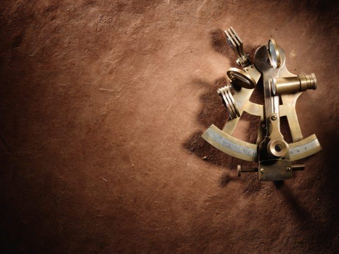 An Image Of A Sextant Against A Brown Background
