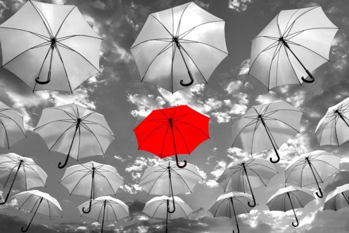 1 Red Umbrella In The Middle Of Many Grey Umbrellas, Standing Out From The Rest. Showing Importance Of Standing Out Online.