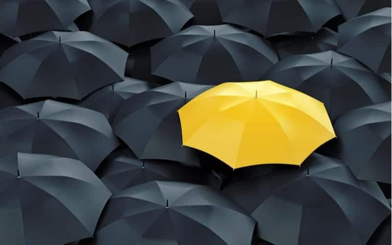 Yellow Umbrella That Sticks Out Among Black Umbrellas