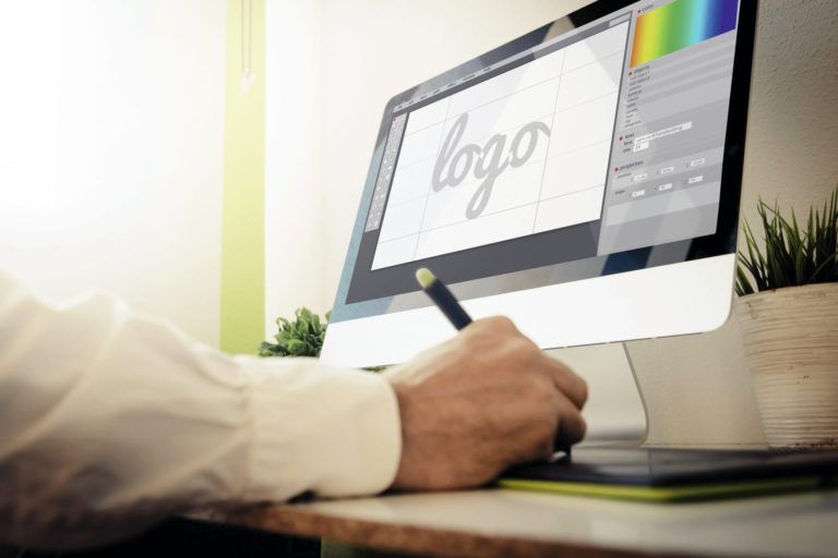 computer showing a logo design software open with designer working on it