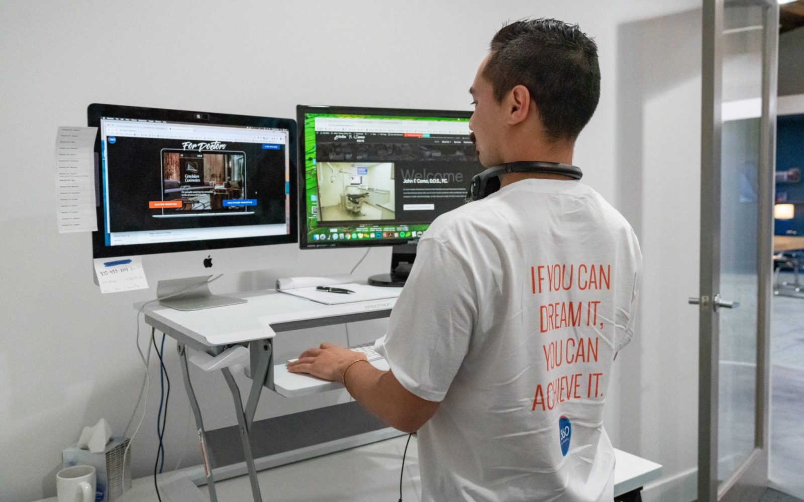 Charles B Standing Behind His Desk Designing A Website