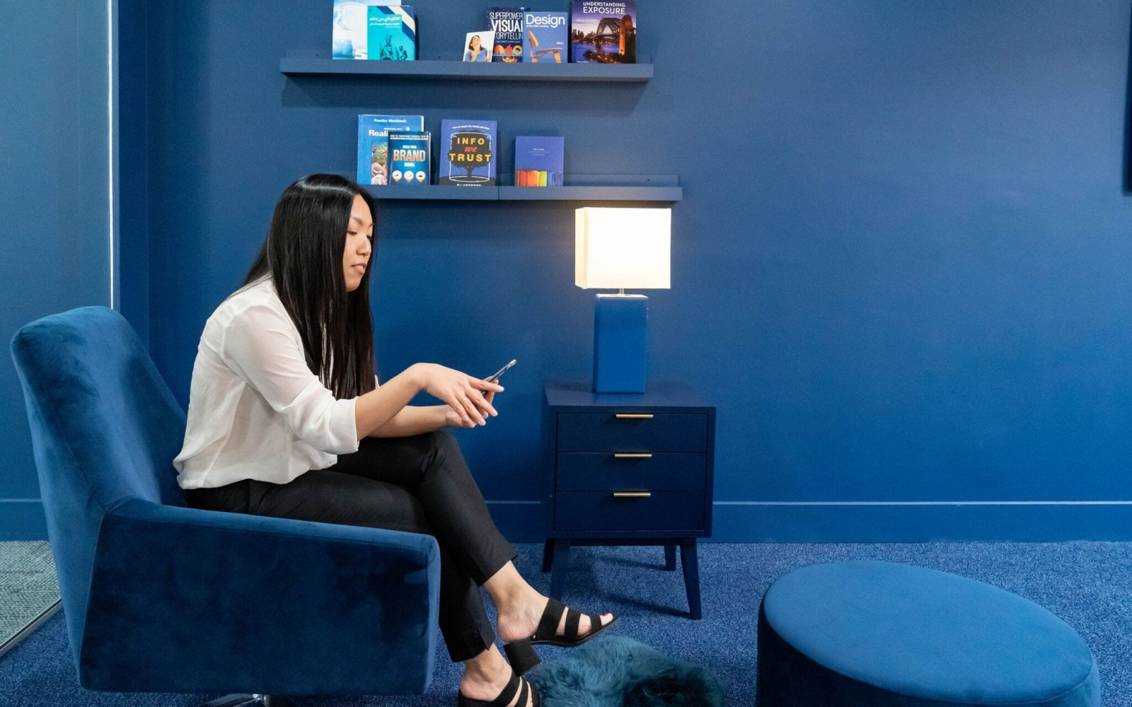 Belinda Tran The Vp Of O360® Sitting On A Blue Chair In The Blue Area Of The O360® Hq