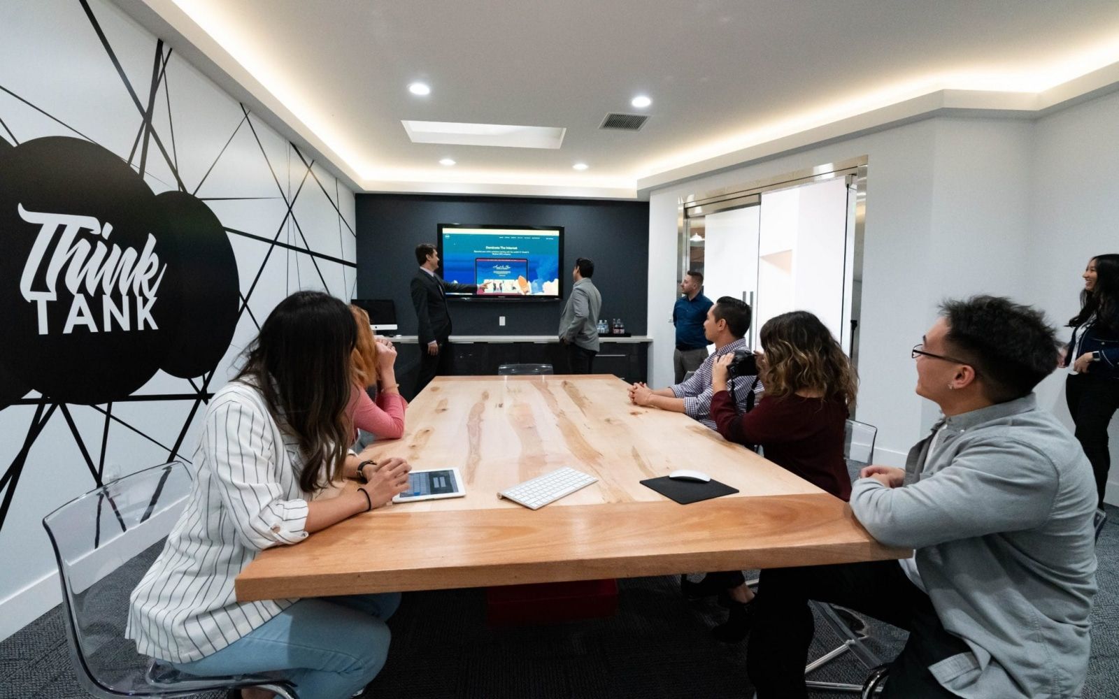 The O360® Team In The Conference Room, With Dr. Sean Pointing At The Monitor