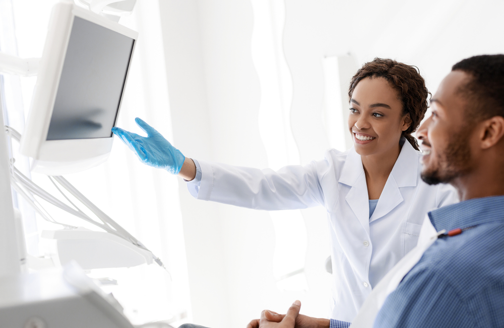 Dentist With Patient Showing Screen